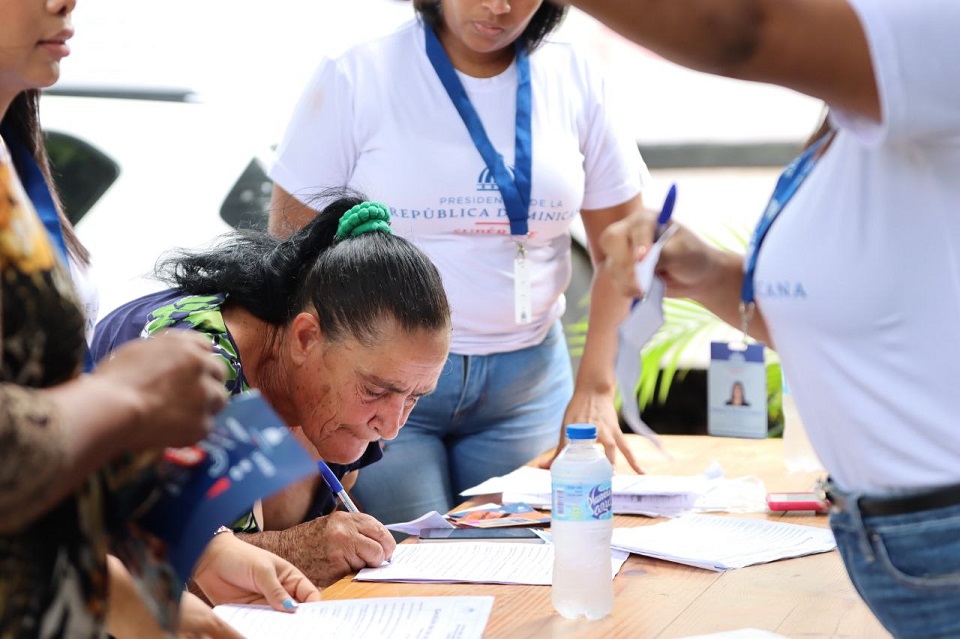 Una de las mujeres beneficiarias de los subsidios de Supérate firma el formulario de datos